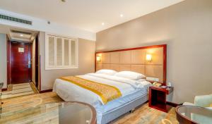 煙台的住宿－Yantai Meiya International ApartHotel (Previous Ramada Plaza)，一间卧室配有一张大床和两把椅子