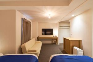 a hospital room with a couch and a tv at Hotel Meriken Port Kobe Motomachi in Kobe