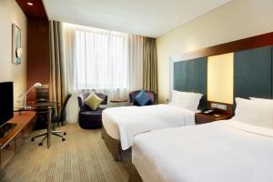 a hotel room with two beds and a desk at Holiday Inn Shanghai Pudong, an IHG Hotel in Shanghai