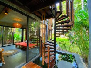 una casa en medio de un jardín con una escalera en LA A NATU Pranburi en Sam Roi Yot