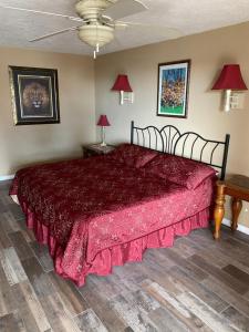 a bedroom with a bed with a red bedspread at Capri Beach Hotel in Corpus Christi