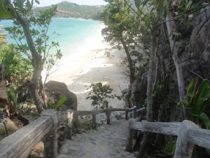 a stairway leading down to a beach with a bench at High Life Bungalow in Haad Yao
