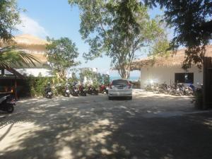 a car parked in a parking lot next to motorcycles at High Life Bungalow in Haad Yao