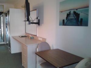 Habitación con escritorio, mesa y una foto de una escalera. en Elsinor Motor Lodge, en Wollongong