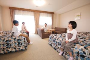 a group of people sitting in a hotel room at Hotel Familio Sadoaikawa in Sado