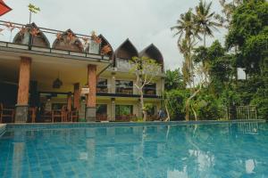 a hotel with a swimming pool in front of a building at Sekar Arum Riverside Resort in Canggu in Tanah Lot