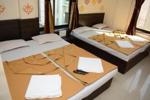 twee bedden naast elkaar in een kamer bij Hotel Sai Sampada NX in Shirdi