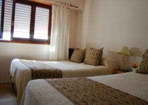 Habitación de hotel con 2 camas y ventana en Hotel La Madrileña en Mar del Plata
