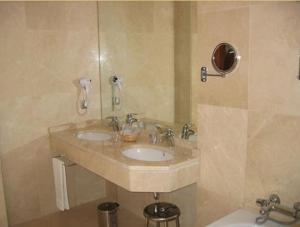 a bathroom with two sinks and a toilet at Hotel Doña Urraca in Zamora