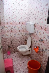 a bathroom with a toilet and a pink wall at Hotel Sai Sampada NX in Shirdi