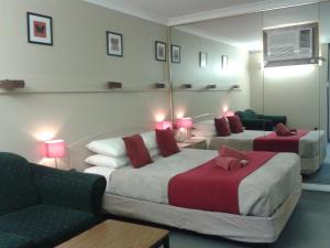 ein Hotelzimmer mit 2 Betten und einem Spiegel in der Unterkunft Elsinor Motor Lodge in Wollongong