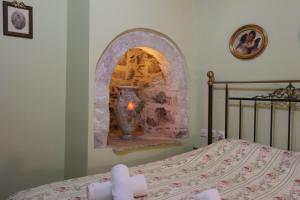 una camera da letto con camino in pietra di Polyxenia Hotel a Nauplia