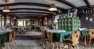a dining room with green tables and chairs at Angerer Alm in Sankt Johann in Tirol