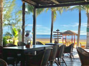 Dolphin Bay Beach Resort في سام رويْ يوت: مطعم على الشاطئ به طاولات وكراسي