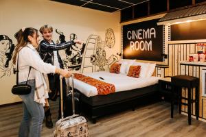 a man and woman standing in a room with a bed at Amsterdam Teleport Hotel - Free Parking in Amsterdam