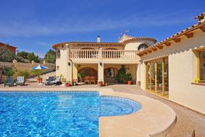 a house with a swimming pool in front of a house at Villa Odisea in Calpe