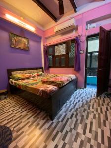 a bedroom with a bed in a purple room at Marigold Guest House in Varanasi