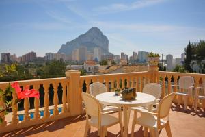 a table and chairs on a balcony with a view of a mountain at Villa Odisea in Calpe