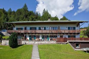 duży dom z gankiem i trawnikiem w obiekcie Haus am Hochwald w mieście Mittenwald