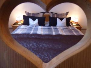 sypialnia z łóżkiem z zagłówkiem w kształcie serca w obiekcie Haus am Hochwald w mieście Mittenwald