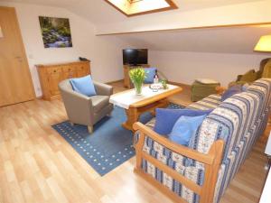 salon z kanapą, stołem i krzesłami w obiekcie Haus am Hochwald w mieście Mittenwald