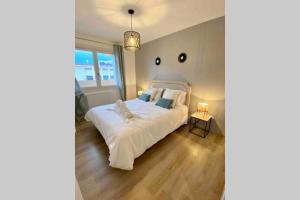 a bedroom with a white bed and a window at Le Continental Beau T2 plein centre + parking in Annecy