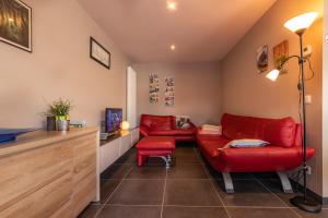 a living room with two red couches and a tv at Ter Ename 3 in Oudenaarde