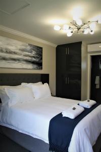 sypialnia z 2 łóżkami i ręcznikami w obiekcie Mahem Manor Guesthouse w mieście Brits