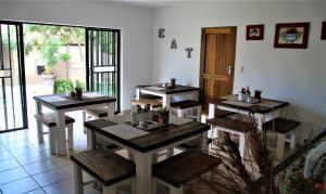 a restaurant with wooden tables and chairs in a room at Mahem Manor Guesthouse in Brits