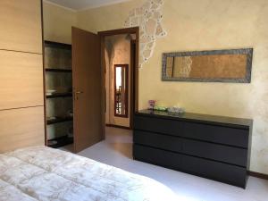 a bedroom with a bed and a dresser at Garda Home Accessible in Padenghe sul Garda
