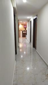 an empty hallway with white walls and a tile floor at Bhumi Residency in Mangalore