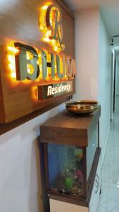 a fish tank in front of a sign in a restaurant at Bhumi Residency in Mangalore