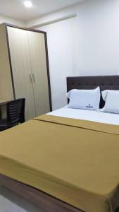 a bedroom with a large bed and a cabinet at Bhumi Residency in Mangalore