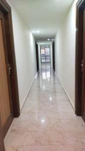 an empty hallway with white walls and a tile floor at Bhumi Residency in Mangalore