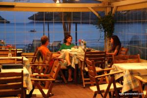 eine Gruppe von Menschen, die an einem Tisch in einem Restaurant sitzen in der Unterkunft Nefeli in Vasiliki