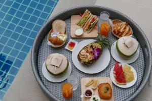 a tray of food on a table next to a pool at Le Tada Parkview Hotel - SHA Plus in Bangkok