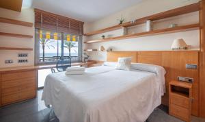 Un dormitorio con una gran cama blanca y una ventana. en R114 Apartment Ca La Laura, en Calafell 21 fotos más