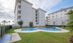 a large apartment building with a swimming pool in a yard at R114 Apartment Ca La Laura in Calafell
