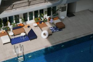 an overhead view of a pool with tables and chairs at Le Tada Parkview Hotel - SHA Plus in Bangkok