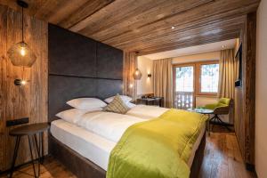 ガルチュールにあるAlpenresort Fluchthornの木製の壁のベッドルーム1室(大型ベッド1台付)