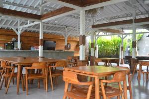 a dining room with wooden tables and chairs at Desaku Bungalows in Canggu