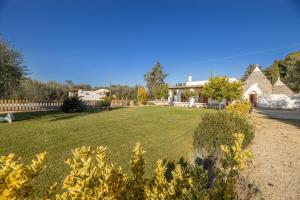un ampio cortile con una casa sullo sfondo di Villa Acqua Azzurra a Ceglie Messapica