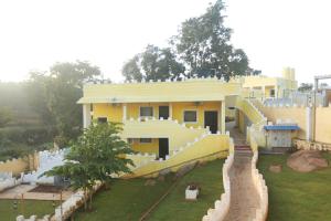 żółty dom ze zjeżdżalnią przed nim w obiekcie Hillfort Hotels & Resorts Yelagiri w mieście Yelagiri