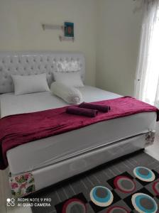 un letto con 2 cuscini e una coperta rosa di Penginapan Rezki Syariah a Bukittinggi