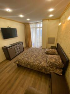 a bedroom with a bed and a flat screen tv at вул Роксолани , 16 центр 300 м до бювету in Truskavets