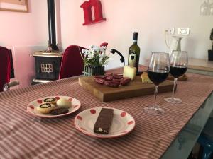 uma mesa com dois copos de vinho tinto e comida em Il giardino incantato em Barrea