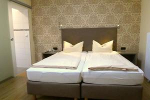 Un dormitorio con dos camas con almohadas blancas. en Hotel Munzert, en Hof