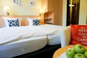 アンダーナッハにあるPanorama Hotel Rheinkroneのベッドとリンゴ付きテーブルが備わるホテルルームです。