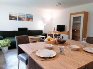 a living room with a wooden table with plates on it at KiEZ Am Filzteich in Schneeberg