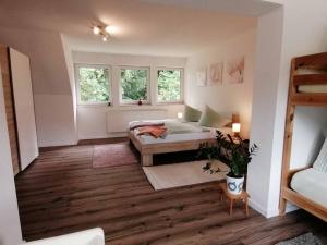 a living room with a bed and two windows at KiEZ Am Filzteich in Schneeberg